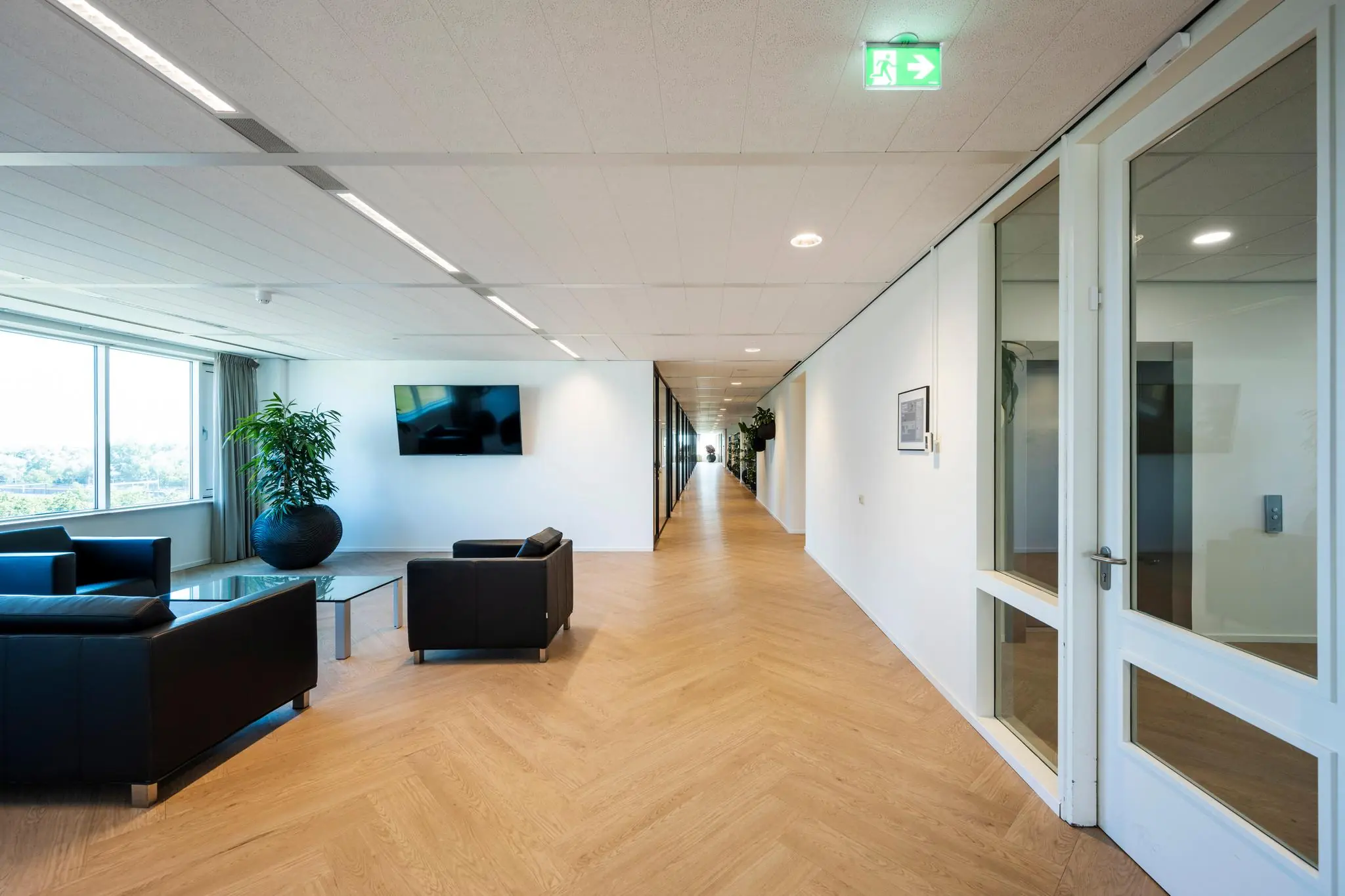 Moderne kantoorruimte aan de Thomas R. Malthusstraat met een wachtruimte, lange gang en houten visgraatvloer.